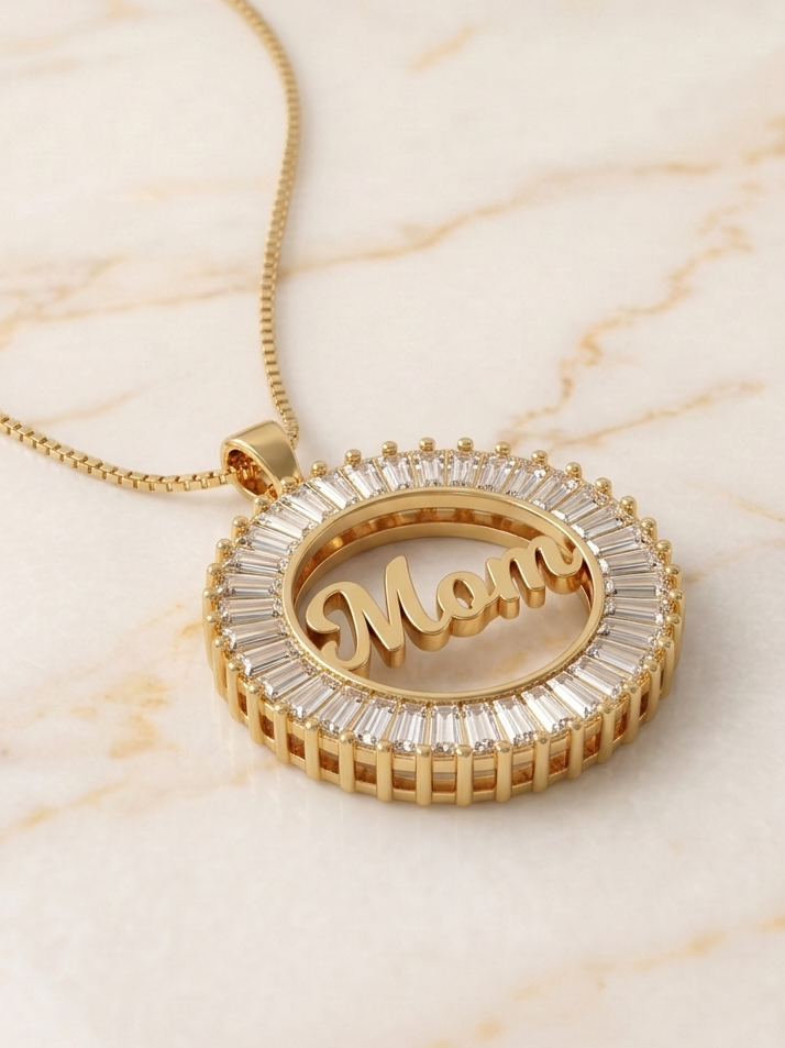 Gold necklace with 'Mom' pendant on a marble surface